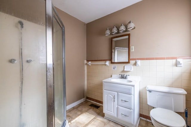 bathroom featuring tile walls, vanity, an enclosed shower, tile patterned floors, and toilet