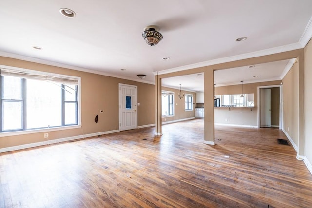 unfurnished living room with crown molding and wood-type flooring