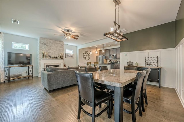 3291 Wild Basil Ln, Buford, GA 30519 - dining area featuring ceiling fan, wood finished floors, and a stone fireplace