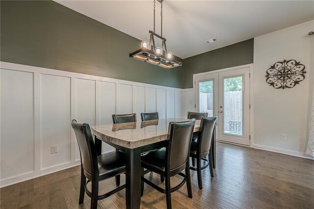 3291 Wild Basil Ln, Buford, GA 30519 - dining space featuring a decorative wall, french doors, dark wood finished floors, wainscoting, and a chandelier