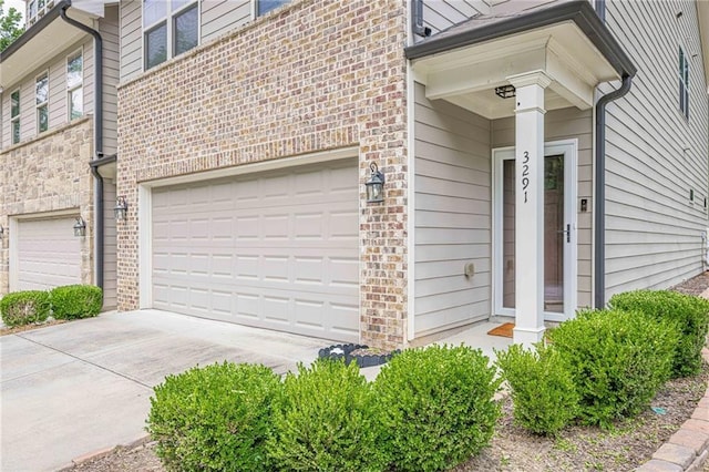 3291 Wild Basil Ln, Buford, GA 30519 - property entrance featuring a garage, driveway, and stone siding