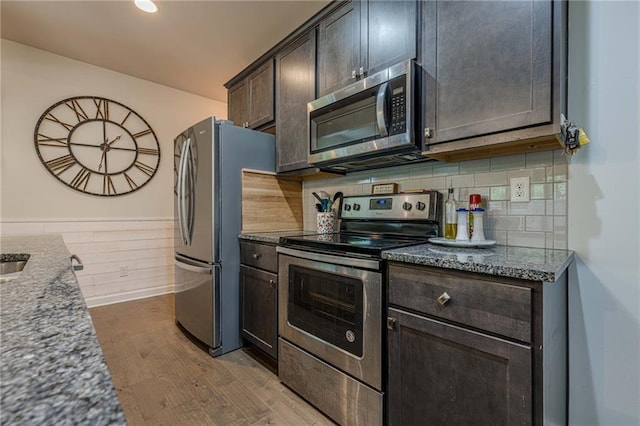 3291 Wild Basil Ln, Buford, GA 30519 - kitchen featuring stainless steel appliances, stone counters, wood finished floors, dark brown cabinets, and wainscoting