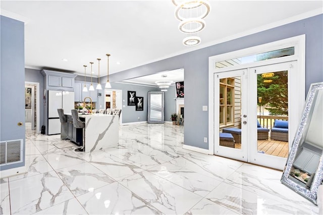 kitchen featuring gray cabinets, hanging light fixtures, ornamental molding, french doors, and white fridge