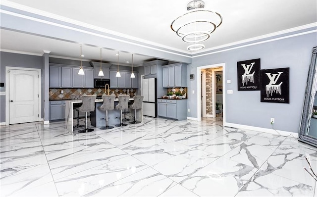 kitchen with pendant lighting, gray cabinetry, a kitchen bar, white fridge, and a kitchen island with sink