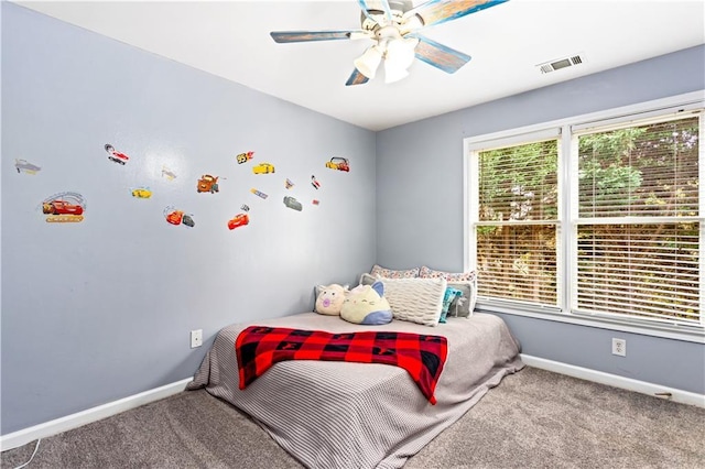 carpeted bedroom featuring multiple windows and ceiling fan