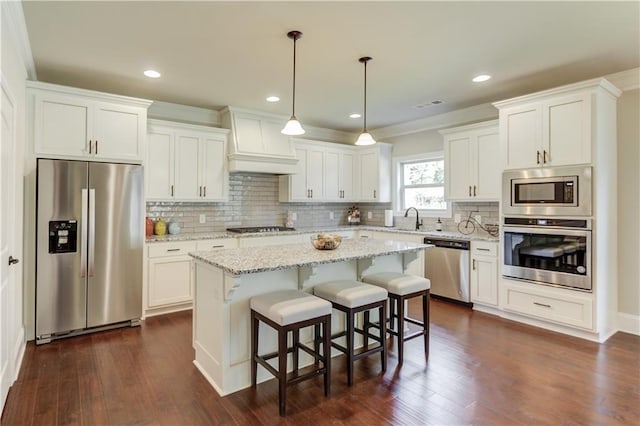 kitchen with premium range hood, white cabinetry, sink, a center island, and stainless steel appliances