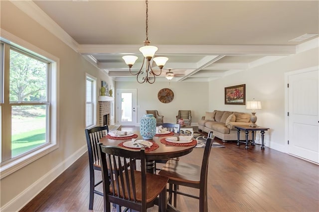 dining space with beamed ceiling, dark hardwood / wood-style flooring, a brick fireplace, and a notable chandelier