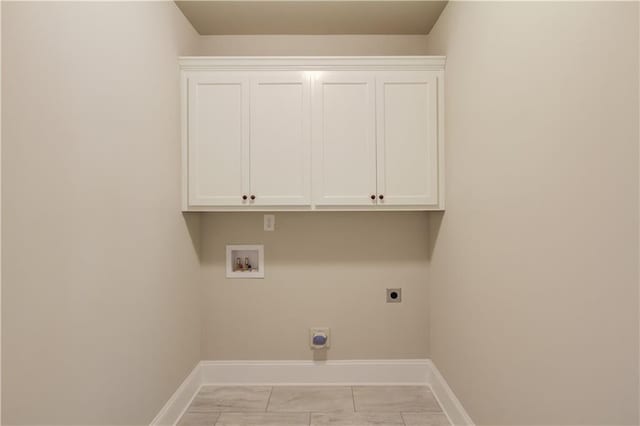 laundry area featuring electric dryer hookup, hookup for a washing machine, and cabinets