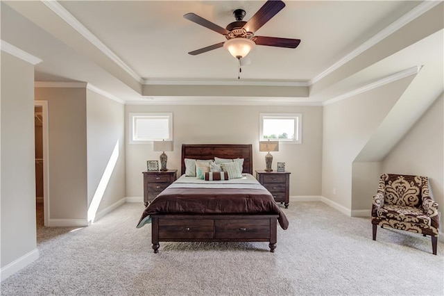 bedroom with crown molding, light colored carpet, a tray ceiling, and ceiling fan