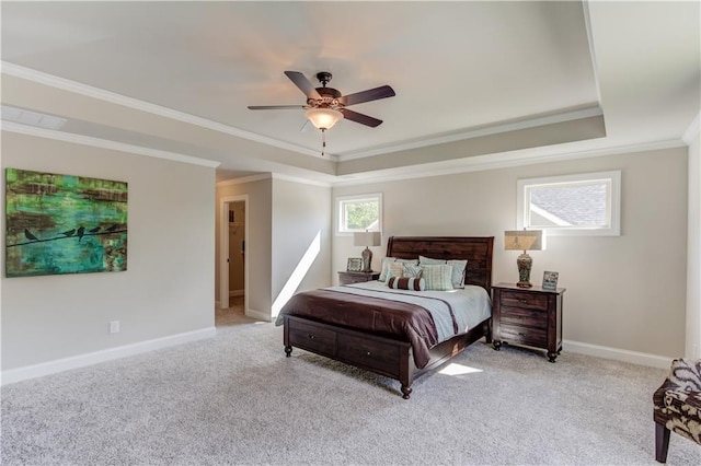 bedroom with ornamental molding, a tray ceiling, and light carpet