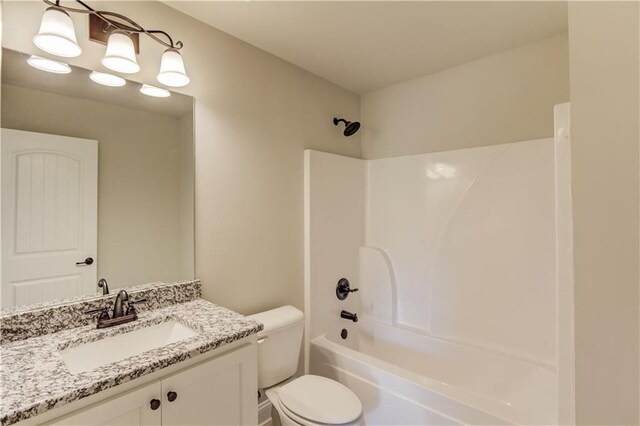 full bathroom featuring bathing tub / shower combination, vanity, and toilet