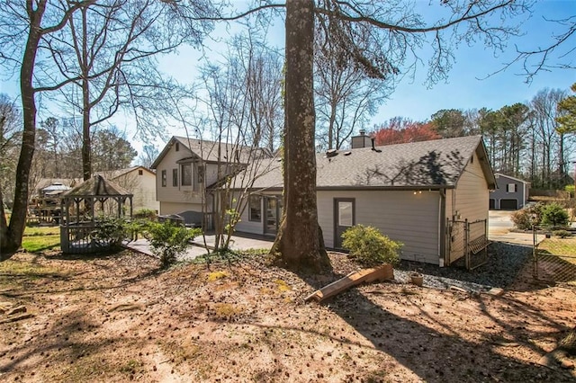 700 Hill Meadow Dr, Dacula, GA 30019 - back of house featuring fence, a gazebo, a shingled roof, a chimney, and a patio area
