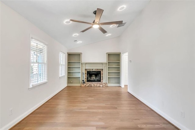 700 Hill Meadow Dr, Dacula, GA 30019 - unfurnished living room with baseboards, ceiling fan, vaulted ceiling, a stone fireplace, and light wood-style flooring