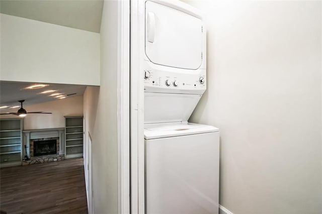 700 Hill Meadow Dr, Dacula, GA 30019 - clothes washing area with ceiling fan, a stone fireplace, laundry area, stacked washer and clothes dryer, and wood finished floors