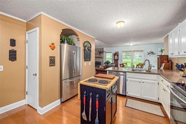 1526 Oakleaf Dr, Auburn, GA 30011 - kitchen with stainless steel appliances, a sink, a peninsula, white cabinets, and a textured ceiling