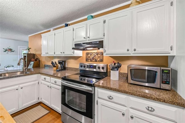 1526 Oakleaf Dr, Auburn, GA 30011 - kitchen with appliances with stainless steel finishes, a sink, under cabinet range hood, a textured ceiling, and white cabinetry