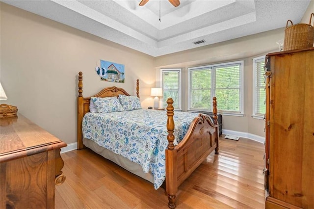 1526 Oakleaf Dr, Auburn, GA 30011 - bedroom featuring a tray ceiling, light wood finished floors, and baseboards