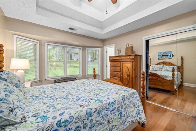 1526 Oakleaf Dr, Auburn, GA 30011 - bedroom with wood finished floors, baseboards, a tray ceiling, and a ceiling fan