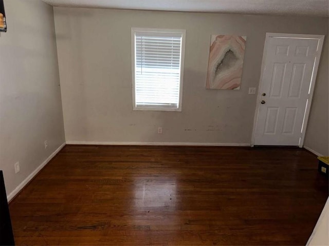 unfurnished room with dark hardwood / wood-style floors