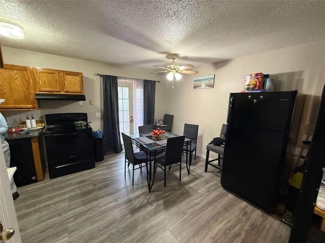 dining area with hardwood / wood-style floors, a textured ceiling, and ceiling fan