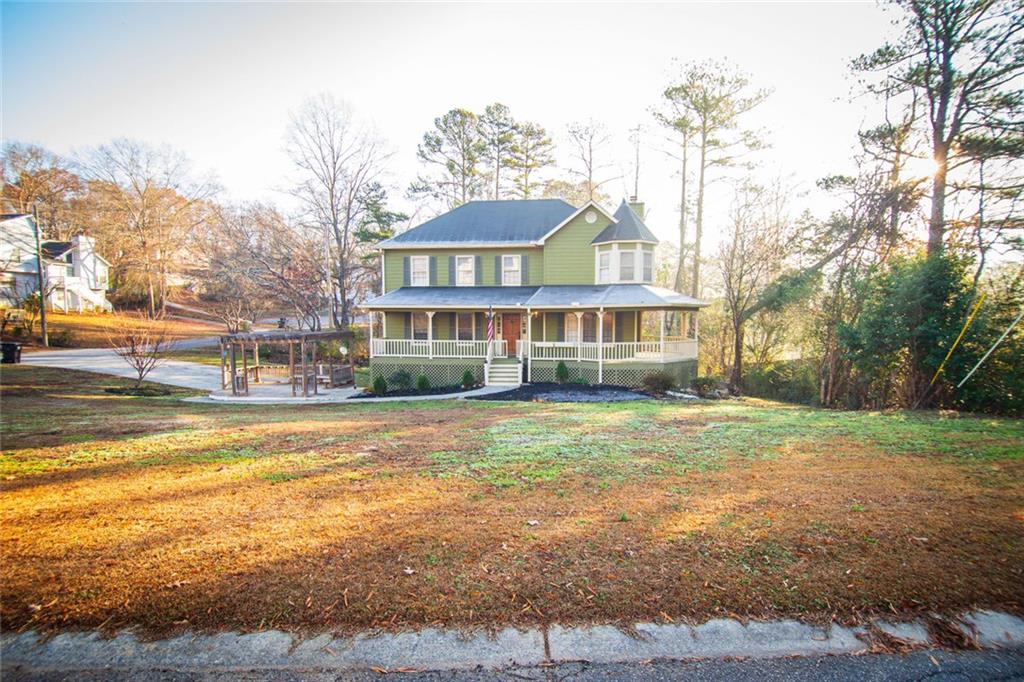 farmhouse-style home with a front lawn and covered porch