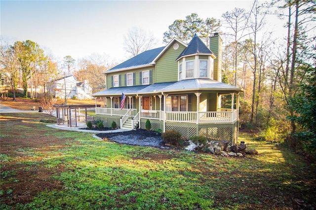 rear view of house with a yard and a porch