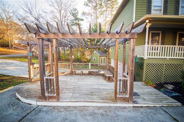 wooden deck featuring a pergola and a storage unit