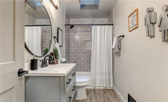 full bathroom featuring vanity, hardwood / wood-style flooring, shower / bath combo, and toilet