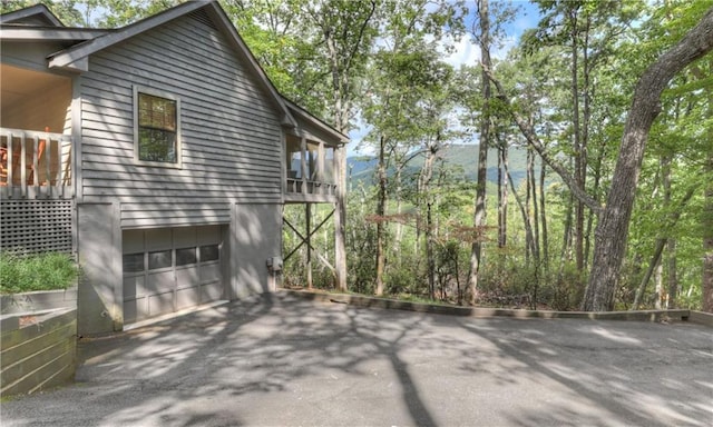 view of home's exterior with a garage, a balcony, and a mountain view