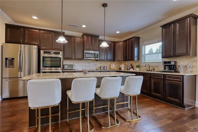 200 Baumgard, Locust Grove, GA 30248 - kitchen with appliances with stainless steel finishes, dark brown cabinetry, crown molding, backsplash, and a center island