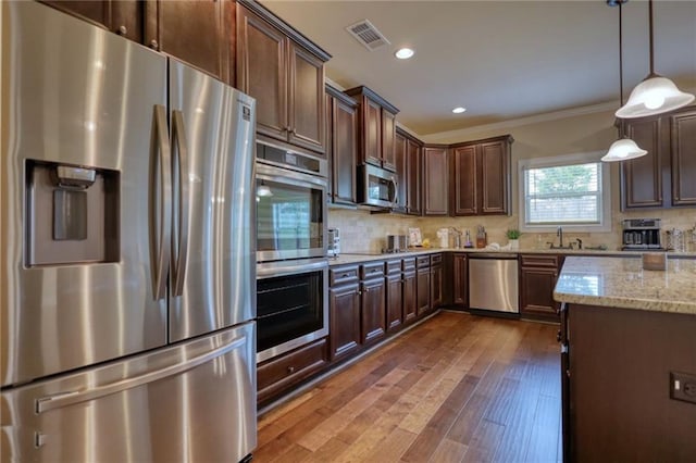200 Baumgard, Locust Grove, GA 30248 - kitchen with stainless steel appliances, light stone countertops, crown molding, dark brown cabinetry, and tasteful backsplash