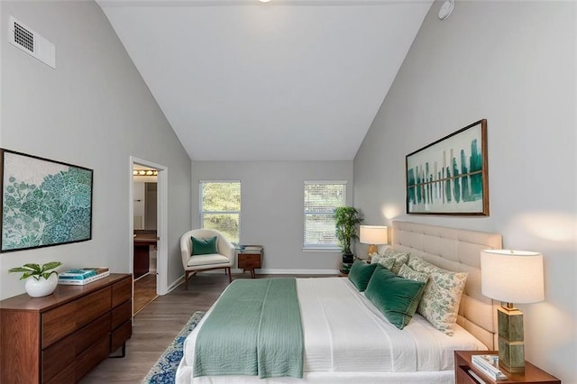 bedroom with connected bathroom, high vaulted ceiling, and wood-type flooring