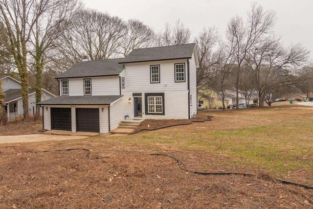 view of property featuring a front yard and a garage