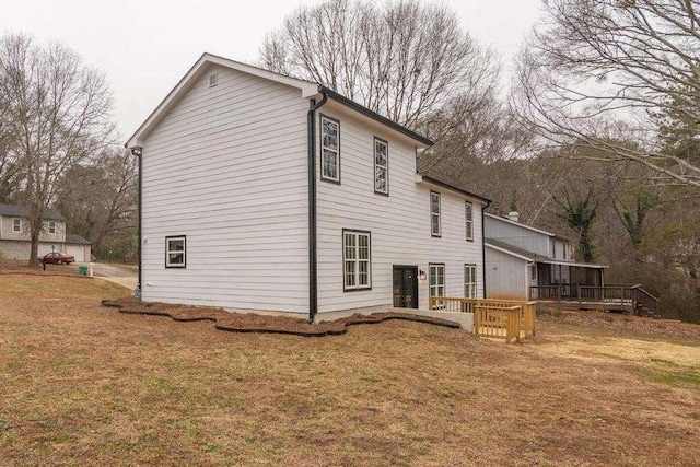 back of house featuring a wooden deck and a yard