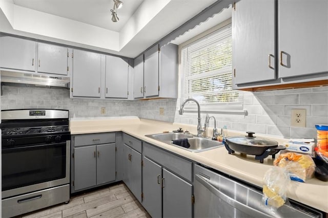 kitchen featuring gray cabinets, sink, backsplash, and appliances with stainless steel finishes