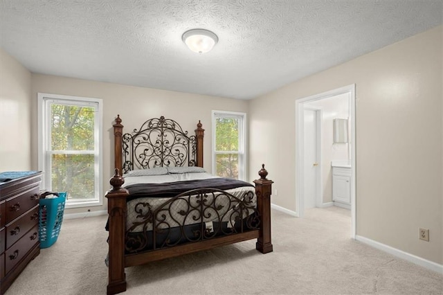 carpeted bedroom with a textured ceiling and ensuite bathroom