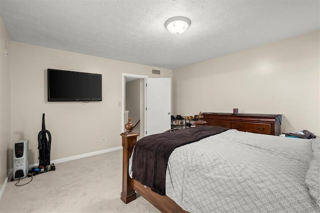 bedroom featuring heating unit, a textured ceiling, and light colored carpet