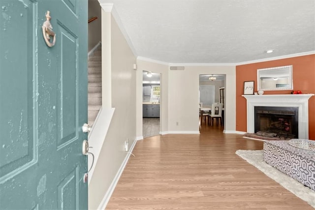 foyer with light hardwood / wood-style floors and crown molding