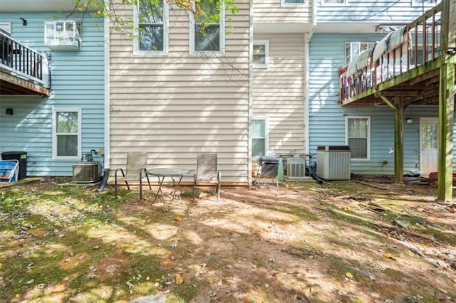 rear view of property featuring a wooden deck and cooling unit