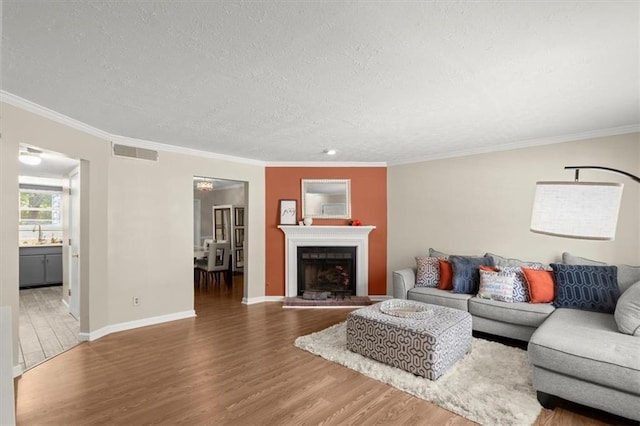 living room featuring dark hardwood / wood-style flooring, a textured ceiling, and ornamental molding