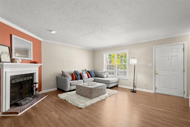 living room featuring a fireplace, hardwood / wood-style flooring, a textured ceiling, and ornamental molding