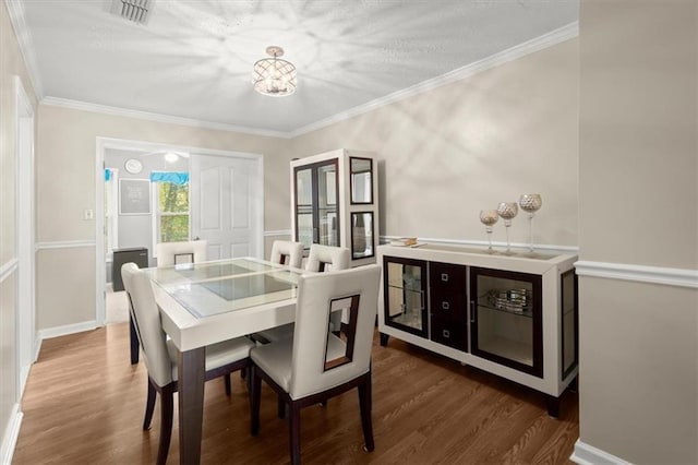 dining room featuring ornamental molding and dark hardwood / wood-style floors