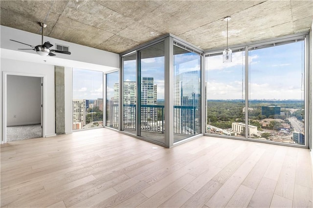3324 Peachtree Rd NE Unit 2518, Atlanta, GA 30326 - empty room with a wall of windows, a view of city, wood finished floors, and a ceiling fan
