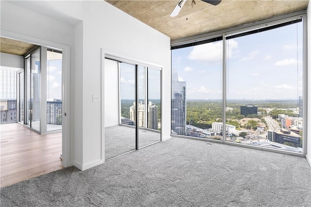 3324 Peachtree Rd NE Unit 2518, Atlanta, GA 30326 - unfurnished bedroom featuring carpet, expansive windows, access to exterior, a view of city, and a ceiling fan