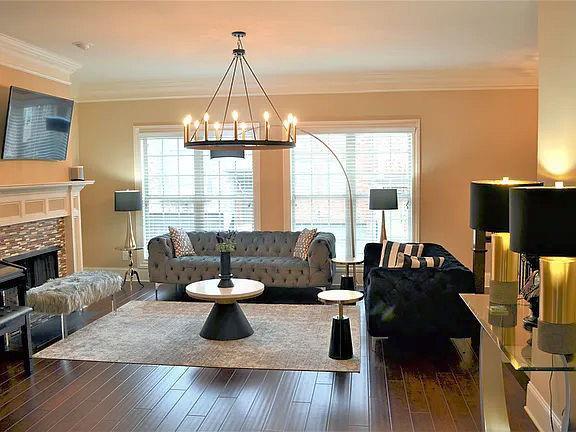 1035 Willow Field Ln SE, Marietta, GA 30067 - living area with an inviting chandelier, ornamental molding, wood finished floors, and a fireplace