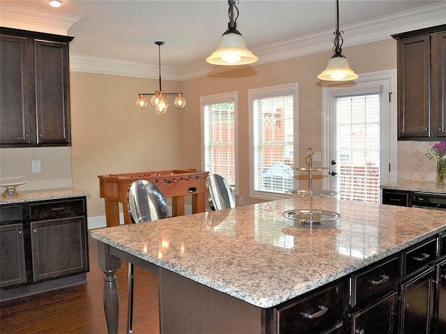 1035 Willow Field Ln SE, Marietta, GA 30067 - kitchen with dark wood finished floors, ornamental molding, light stone counters, and a kitchen island