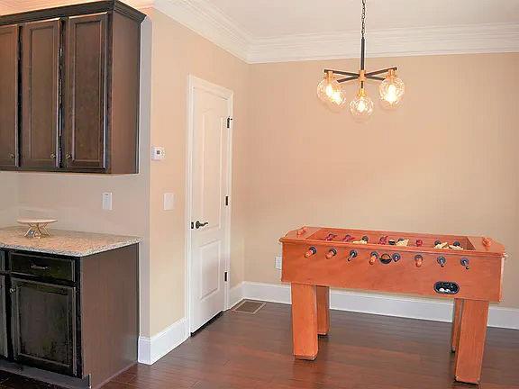 1035 Willow Field Ln SE, Marietta, GA 30067 - recreation room with a notable chandelier, dark wood finished floors, baseboards, and ornamental molding