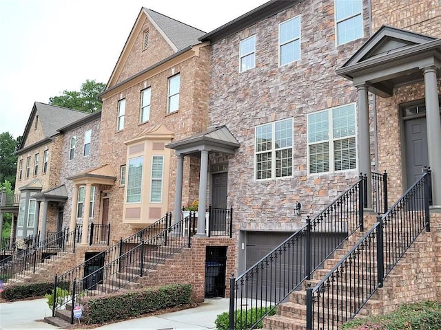 1035 Willow Field Ln SE, Marietta, GA 30067 - townhome / multi-family property with stairway, driveway, stone siding, and a garage
