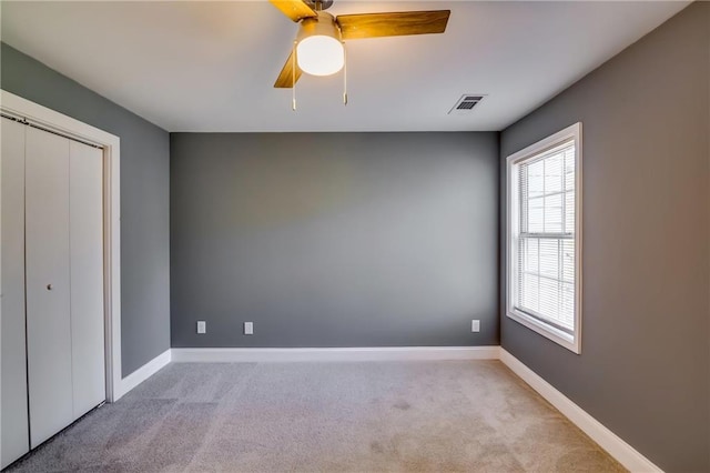 unfurnished bedroom with ceiling fan, a closet, and light colored carpet