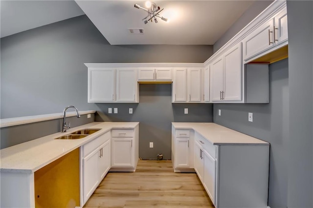 kitchen featuring light hardwood / wood-style floors, white cabinetry, and sink